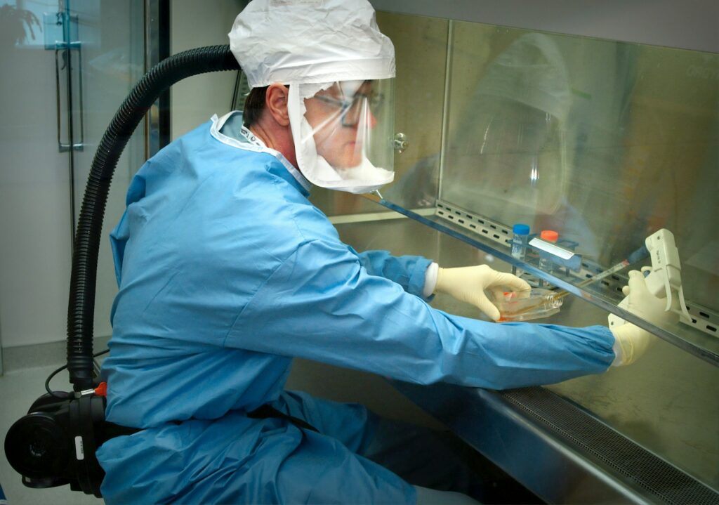 a man in a protective suit and mask working on a machine